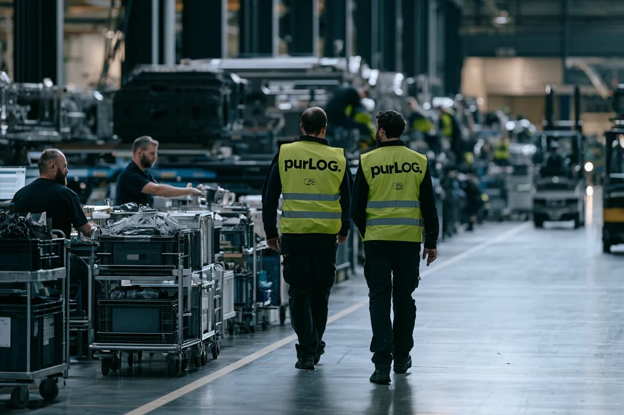 Zwei purLOG-Mitarbeiter in Warnwesten in der Produktionshalle eines Kunden